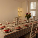 Cath Kidson inspired Dining room with enough place settings of china, crockery and glassware to seat 20